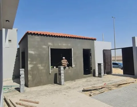 ملحق قيد البناء بسقف قرميد أحمر في حوش منزل