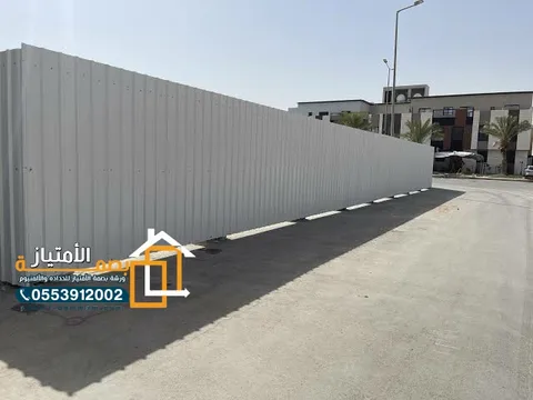 سور تحويش معدني رمادي حول موقع إنشاء في الأحساء