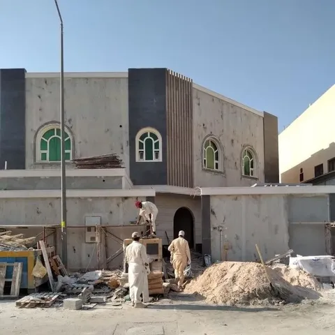 ترميم واجهة منزل بلونين مع أعمال البناء أمامه في النعيرية